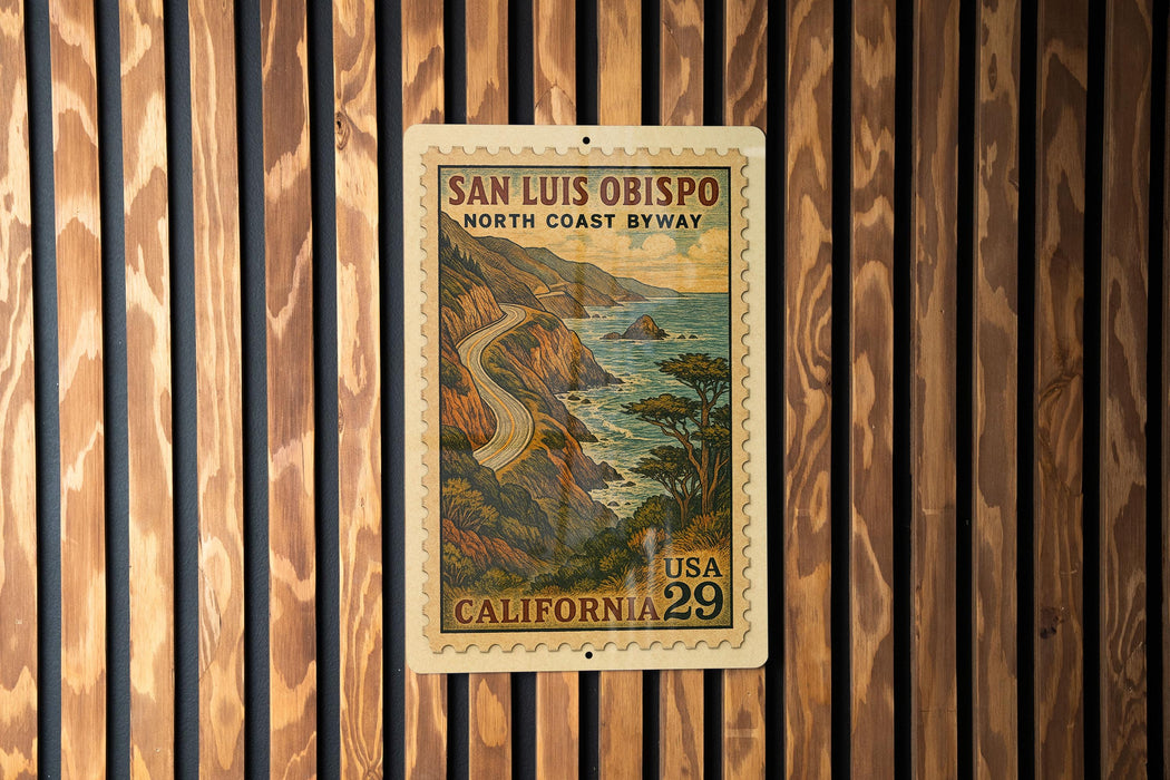 A vintage postage stamp from the United States of America, featuring a scenic coastal landscape with a winding road and mountains in the background.