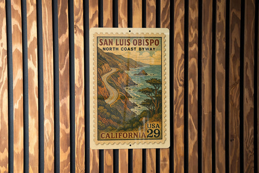 A vintage postage stamp from the United States of America, featuring a scenic coastal landscape with a winding road and mountains in the background.