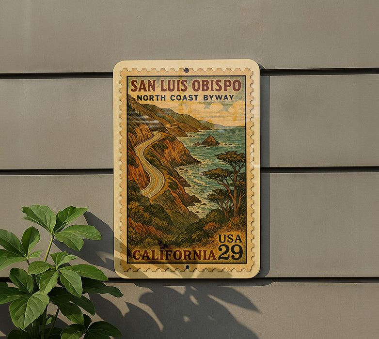 A vintage-style postage stamp depicting a scenic coastal road in California, with the text "SAN LUIS OBISPO NORTH COAST BYWAY" and "USA 29 CALIFORNIA".