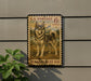 A U.S. postage stamp featuring a dog, specifically an Alaskan Klee Kai, is displayed on a wall.