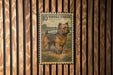 A postage stamp featuring a dog, specifically a Norfolk Terrier, is displayed on a wooden wall.
