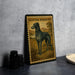 A framed illustration of a Scottish deerhound dog is displayed on a wall, with a plate of food and a camera lens visible to the left.