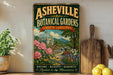 a vintage-style sign for the Asheville Botanical Gardens in North Carolina, with a lush garden scene and a greenhouse in the background.