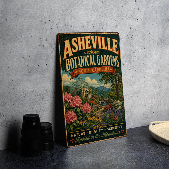 A vintage-style metal sign for the Asheville Botanical Gardens in North Carolina, featuring a colorful illustration of a garden with flowers and a dome-shaped building.