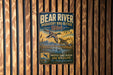 A vintage metal sign with a bird illustration and text, mounted on a wooden wall.