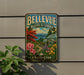 A vintage-style metal sign for the Bellevue Botanical Garden in Washington, featuring a colorful illustration of the garden and surrounding landscape.