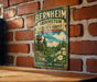 A vintage-style metal sign for the Bernheim Arboretum and Research Forest in Kentucky, featuring a scenic landscape with a water tower and flowers.