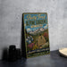 A vintage-style metal sign for Betty Ford Alpine Gardens in Colorado, featuring a scenic mountain landscape with colorful flowers and plants.