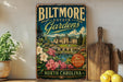A vintage-style metal sign for Biltmore Estate Gardens in North Carolina, featuring a castle and garden illustration.