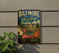 A vintage-style metal sign for the Biltmore Estate Gardens in North Carolina, featuring a castle and garden scene.