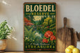 A vintage-style sign for Bloedel Reserve, featuring a scenic landscape with a bridge, trees, and flowers, is displayed on a wooden shelf next to a potted plant and a cutting board.