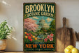 A vintage-style metal sign for the Brooklyn Botanic Garden, featuring a colorful illustration of the greenhouse and surrounding landscape, with the text "Brooklyn Botanic Garden" and "Est. 1910 NEW YORK CULTIVATING EDUCATION CONSERVATION".
