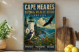A vintage-style metal sign for Cape Meares National Wildlife Refuge in Oregon, featuring a lighthouse, puffin, and eagle, along with the text "PROTECT PRESERVE REFUGE Wildlife Comes First".