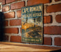 A vintage metal sign for Cape Romain National Wildlife Refuge in South Carolina, featuring a beach scene with a lighthouse and a bird in flight.