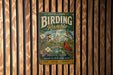 A vintage-style metal sign for Central Park's Birding Ramey, featuring illustrations of birds and text promoting the park's natural beauty and community.