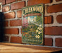 A vintage-style metal sign for Cheekwood Estate & Gardens in Tennessee, featuring a painting of a house surrounded by flowers and a garden.
