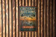 A vintage metal sign for Cheyenne Bottoms Wetlands in Kansas, featuring an illustration of a bird and a sunset over a body of water.