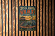 A vintage-style metal sign for the Coastal Virginia Wildlife Observationatory, featuring an illustration of a bird and a wooden structure, mounted on a wooden wall.