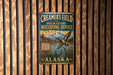 A vintage metal sign for Creamer's Field migratory waterfowl refuge in Alaska, featuring a bird in flight and a serene landscape.