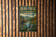 A vintage metal sign for the Dead Creek Wildlife Management Area in Vermont, featuring a scenic illustration of a river, mountains, and wildlife.