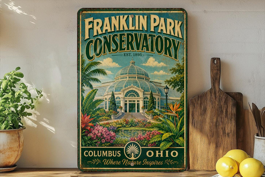 A vintage-style metal sign for Franklin Park Conservatory in Columbus, Ohio, featuring a tropical garden scene with palm trees, colorful flowers, and a large greenhouse structure.