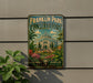 A vintage Franklin Park Conservatory sign is displayed on a wall, featuring a colorful illustration of the conservatory surrounded by tropical plants and flowers.