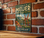 A vintage metal sign for Frederik Meijer Gardens & Sculpture Park in Michigan, featuring a large sculpture and a scenic landscape.