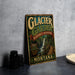 A vintage-style metal sign advertising Glacier Garden, a rainforest adventure in Montana, with a waterfall and wooden bridge in the background.