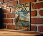 A vintage-style metal sign for the Golden Gate Raptor Observatory in California, featuring an illustration of a hawk perched on a rock with the Golden Gate Bridge in the background.