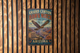 A vintage-style metal sign for Grand Canyon Hawk Watch, featuring an eagle in flight and the text "Grand Canyon Hawk Watch" and "Arizona" in a decorative font.