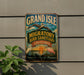A vintage-style metal sign for the Grand Isle Migratory Bird Sanctuary in Louisiana, featuring illustrations of pelicans and a sunset.