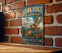 A vintage metal sign for the Hawk Ridge Bird Observatory in Duluth, Minnesota, featuring an illustration of a hawk in flight and the text "Discover the Wonder of Migration".