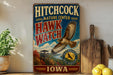 A vintage-style metal sign for the Hitchcock Nature Center in Iowa, featuring an illustration of a hawk in flight and a scenic landscape.