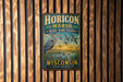 A vintage metal sign for the Horicon Marsh Bird Sanctuary in Wisconsin, featuring an illustration of a heron and ducks in a grassy area with a sunset in the background.