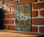 A vintage-style sign for the International Peace Garden in North Dakota, featuring an illustration of the garden with American and Canadian flags, flowers, and a bird.
