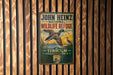 A vintage-style metal sign for John Heinz National Wildlife Refuge in Pennsylvania, featuring a duck in flight and a scenic landscape.