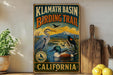 A vintage-style metal sign for the Klath Basin Birding Trail in California, featuring illustrations of various birds in a natural setting.