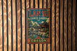 A vintage metal sign with the text "LAN SU CHINESE GARDEN OREGON" displayed on a wooden wall.