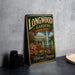 A vintage-style metal sign for Longwood Gardens in Pennsylvania, featuring a fountain and flowers, is displayed on a gray countertop next to a stack of black camera lenses.