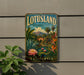 A vintage-style metal sign for Lotusland, a botanical paradise in California, featuring a tropical landscape with palm trees, a pond, and colorful flowers.