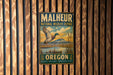 A metal sign with a bird illustration and text, mounted on a wooden wall.