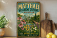 A vintage-style metal sign for the Matthaei Botanical Gardens in Michigan, featuring a lush garden scene with flowers, plants, and a greenhouse.