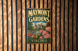A vintage metal sign for Maymont Estate Gardens in Virginia, featuring a garden scene with a fountain and colorful flowers.