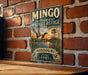 A vintage-style metal sign for the Missouri Wildlife Refuge, featuring a duck in flight and a serene landscape, mounted on a brick wall.