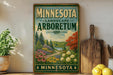A vintage-style sign for the Minnesota Landscape Arboretum, featuring a scenic landscape with trees, flowers, and a winding path.
