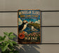 A vintage-style metal sign for the Monhegan Island Bird Sanctuary in Maine, featuring illustrations of puffins and seagulls.