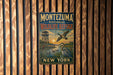 A vintage-style metal sign for the Montezuma National Wildlife Refuge in New York, featuring a bird flying over a lake and a bird standing on a branch.