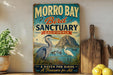 a vintage-style sign for Morro Bay Bird Sanctuary, California, with illustrations of a heron and a bird in a pond. The sign also includes the text "A HAVEN FOR BIRDS A TREASURE for ALL".