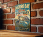 A vintage-style sign for Morro Bay Bird Sanctuary in California, featuring illustrations of birds and a scenic landscape.