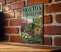 A vintage-style metal sign for the Morton Arboretum in Illinois, featuring a scenic landscape with trees, flowers, and a sign for the Morton Arboretum.